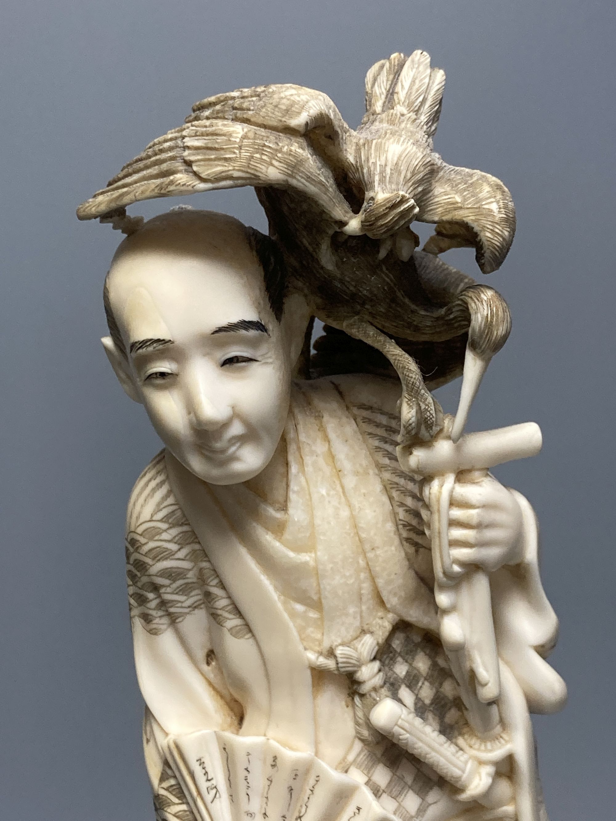 A Japanese walrus ivory okimono of a cormorant fisherman, early 20th century, overall height 34cm